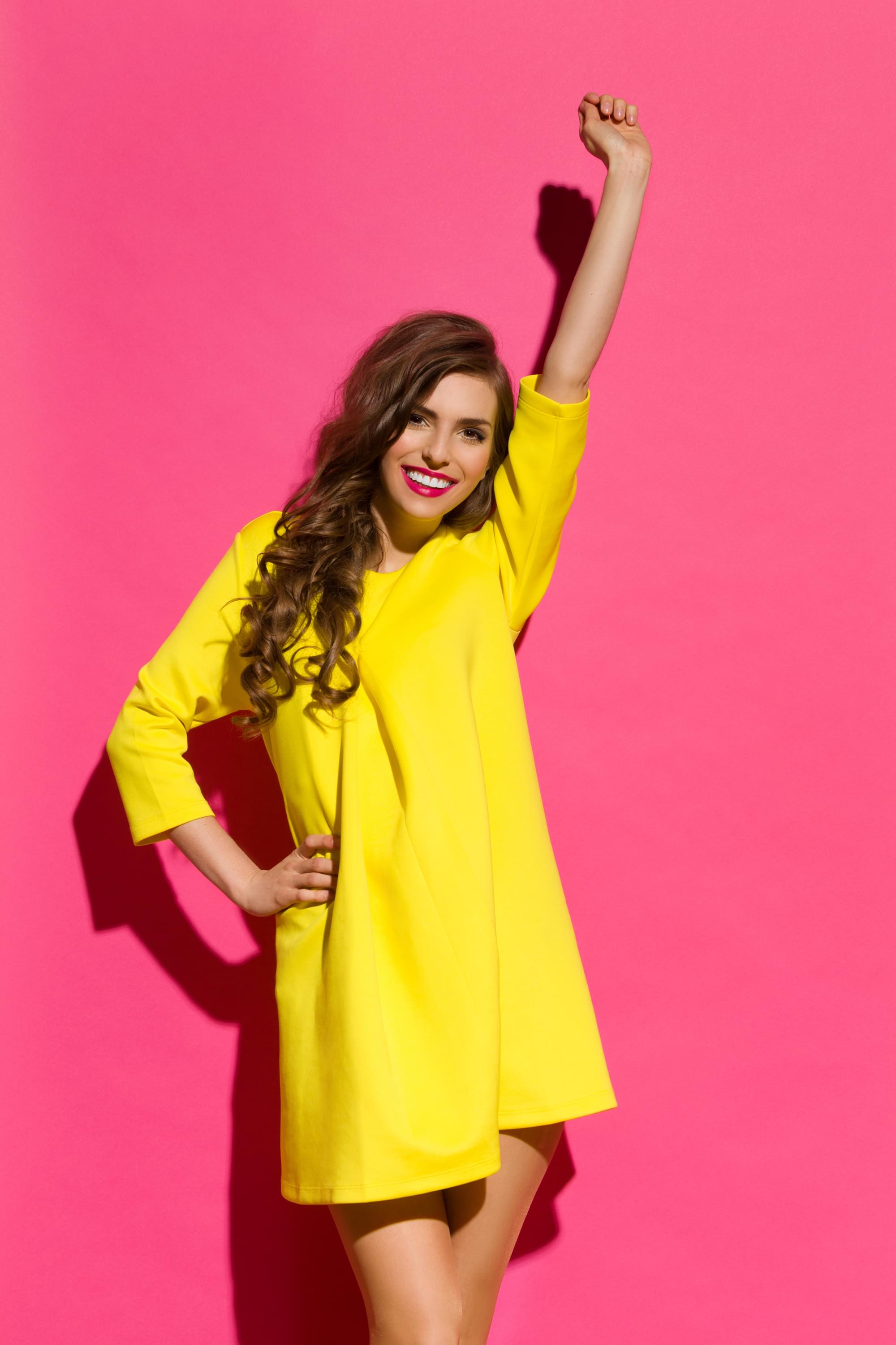 Girl in yellow dress raising her arm